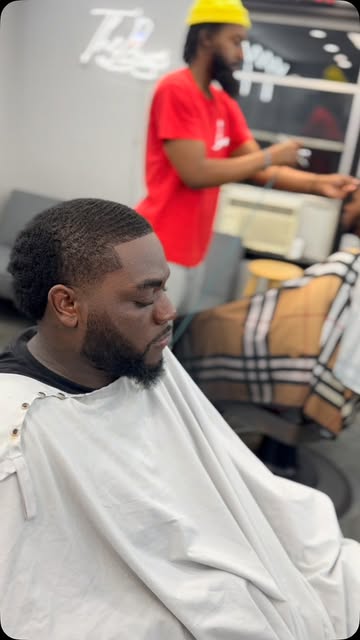Barber shaping a fresh cut at The Luxe